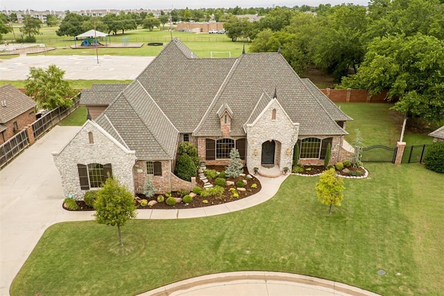 1505 SW 113th Pl, Oklahoma City, OK 73170 - french country home featuring stone siding, a fenced backyard, and brick siding
