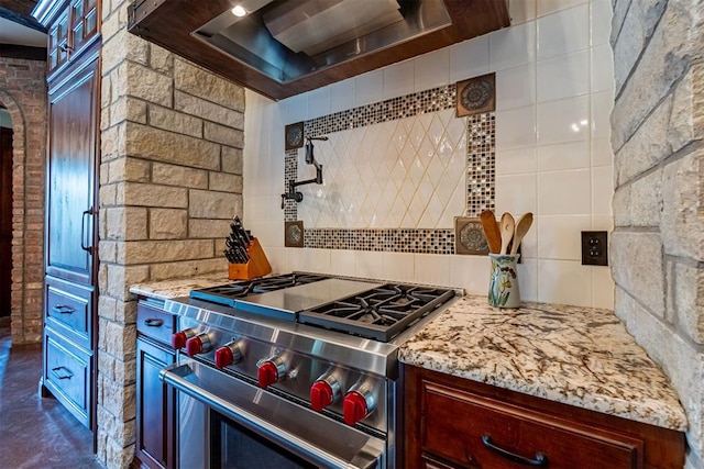 1505 SW 113th Pl, Oklahoma City, OK 73170 - kitchen featuring stainless steel stove, backsplash, range hood, light stone countertops, and arched walkways