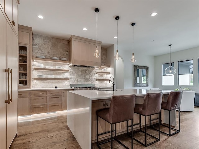 2917 Piazza Ct, Arcadia, OK 73007 - kitchen with light countertops, decorative backsplash, a breakfast bar, a center island with sink, and recessed lighting
