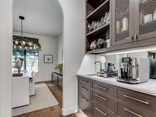 2917 Piazza Ct, Arcadia, OK 73007 - bar featuring wood finished floors, arched walkways, and hanging light fixtures