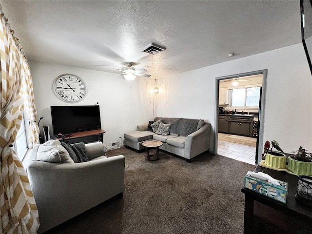 6338 Norman Rd, Warr Acres, OK 73122 - living area featuring ceiling fan, light carpet, and a textured ceiling
