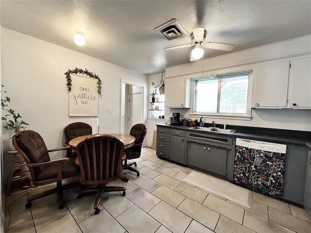 6338 Norman Rd, Warr Acres, OK 73122 - kitchen with dishwasher, dark countertops, white cabinets, and a ceiling fan