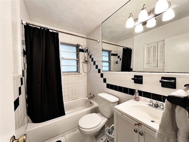 6338 Norman Rd, Warr Acres, OK 73122 - bathroom with tile walls, vanity, shower / bath combo with shower curtain, and a textured ceiling