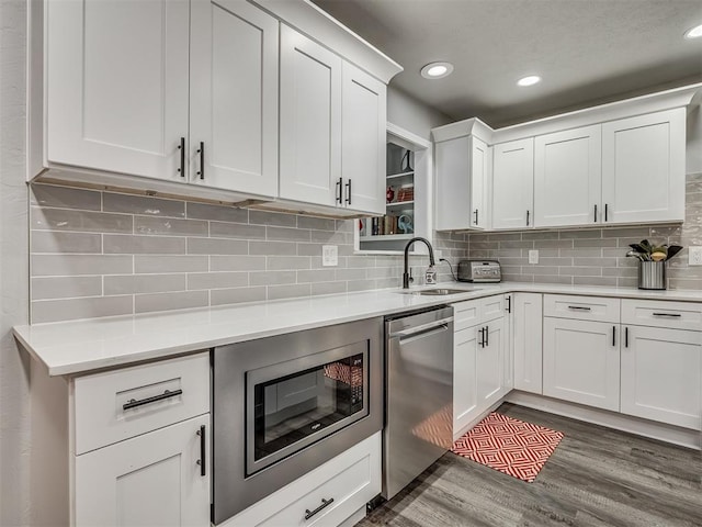 10505 Lyndon Rd, The Village, OK 73120 - kitchen with appliances with stainless steel finishes, light countertops, white cabinets, decorative backsplash, and recessed lighting