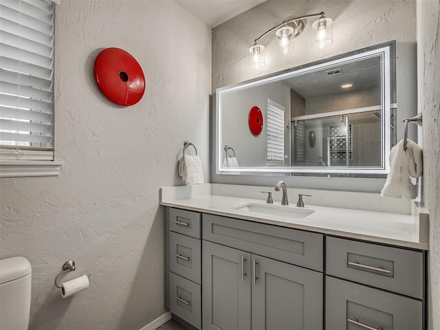10505 Lyndon Rd, The Village, OK 73120 - bathroom featuring vanity, a textured wall, and a shower with shower door