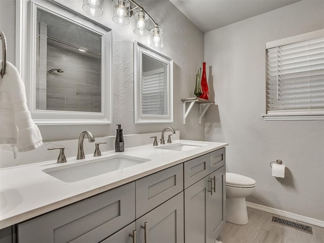 10505 Lyndon Rd, The Village, OK 73120 - bathroom with double vanity, tiled shower, and wood finished floors