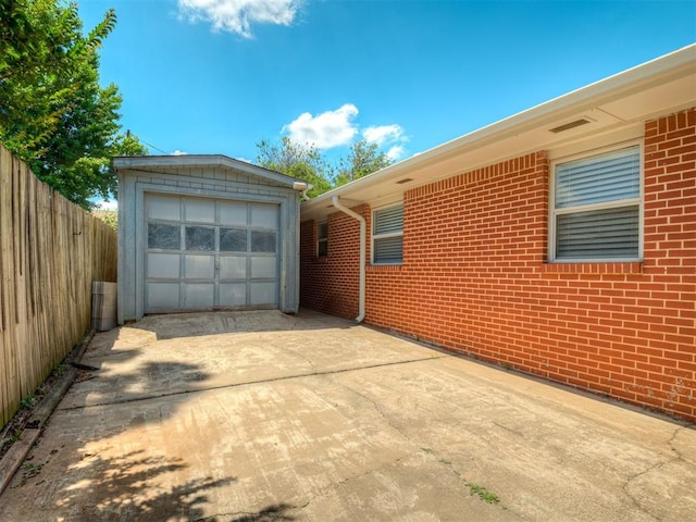 10505 Lyndon Rd, The Village, OK 73120 - view of home's exterior with driveway, an outbuilding, brick siding, and a garage