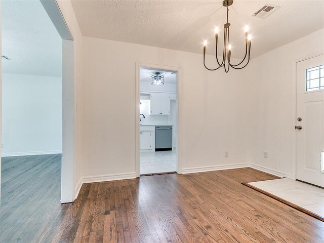 213 E Haddock St, Norman, OK 73069 - entryway with a chandelier, wood finished floors, and a textured ceiling