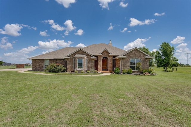 2858 Fields Rd, El Reno, OK 73036 - view of front of home with brick siding, a front lawn, a chimney, and a shingled roof