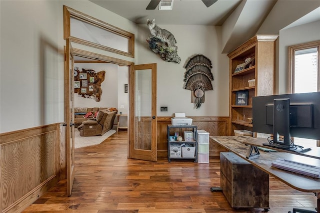 2858 Fields Rd, El Reno, OK 73036 - home office with french doors, a wainscoted wall, wood finished floors, a ceiling fan, and wooden walls