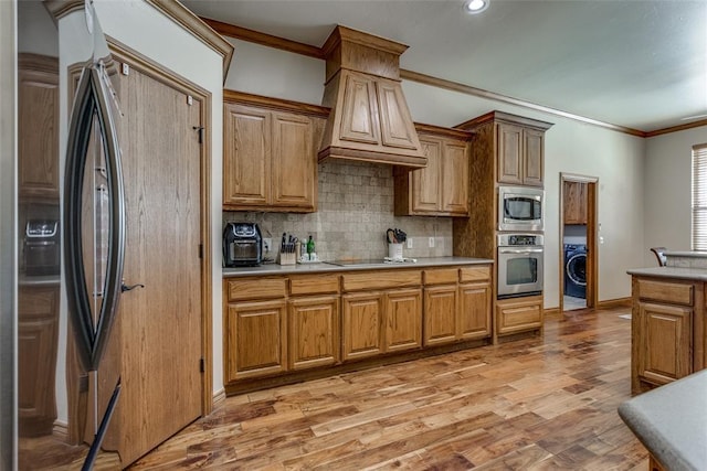2858 Fields Rd, El Reno, OK 73036 - kitchen featuring appliances with stainless steel finishes, crown molding, decorative backsplash, light countertops, and washer / clothes dryer