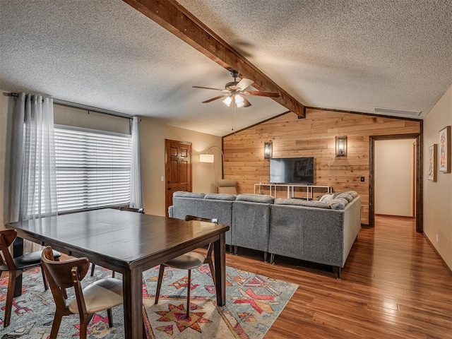 2104 Tanglewood Dr, Edmond, OK 73013 - dining area featuring wooden walls, wood finished floors, a textured ceiling, and a ceiling fan