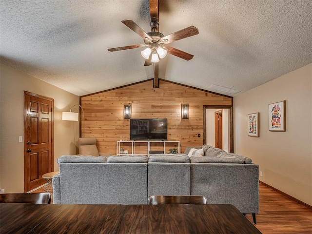 2104 Tanglewood Dr, Edmond, OK 73013 - living area with wooden walls, lofted ceiling, ceiling fan, a textured ceiling, and wood finished floors