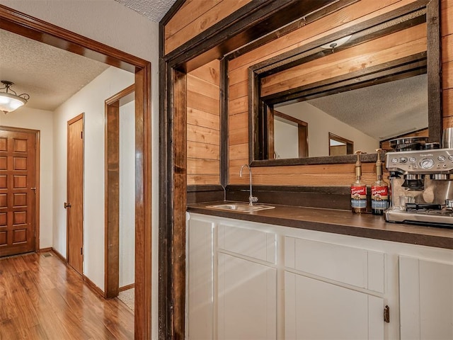 2104 Tanglewood Dr, Edmond, OK 73013 - indoor wet bar featuring a textured ceiling and light wood-type flooring