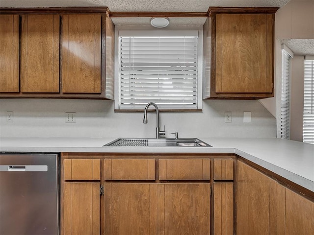 2104 Tanglewood Dr, Edmond, OK 73013 - kitchen with dishwasher, light countertops, brown cabinetry, and a textured ceiling