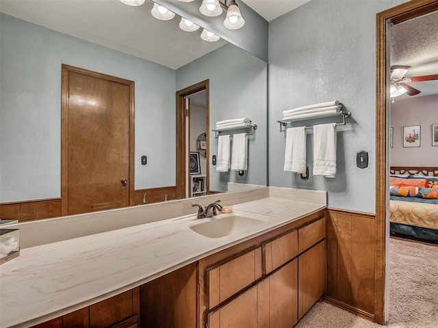 2104 Tanglewood Dr, Edmond, OK 73013 - bathroom with connected bathroom, vanity, wainscoting, and a ceiling fan