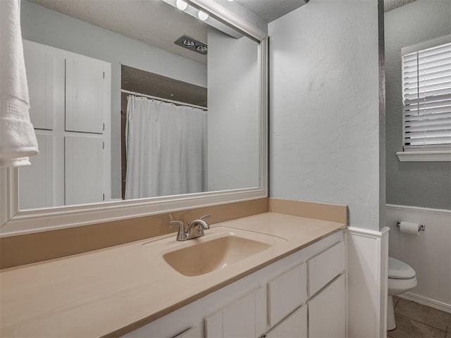 2104 Tanglewood Dr, Edmond, OK 73013 - bathroom with a textured wall, vanity, and a wainscoted wall