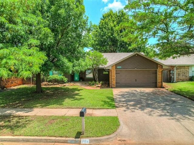 2104 Tanglewood Dr, Edmond, OK 73013 - view of front facade with an attached garage, a front yard, concrete driveway, and brick siding