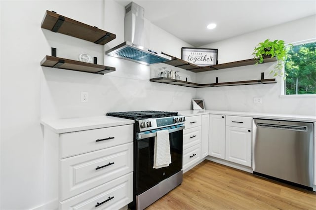8300 S Anderson Rd, Oklahoma City, OK 73150 - kitchen with open shelves, stainless steel appliances, wall chimney exhaust hood, white cabinetry, and light wood-type flooring