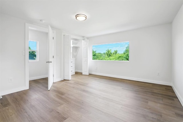 8300 S Anderson Rd, Oklahoma City, OK 73150 - unfurnished bedroom with multiple windows and wood finished floors
