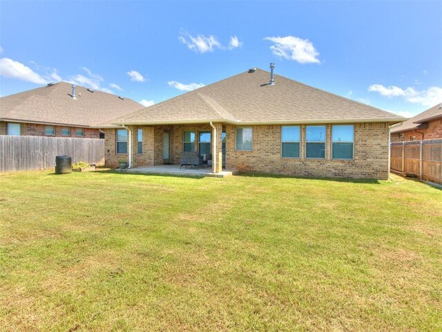 6713 NW 149th St, Oklahoma City, OK 73142 - rear view of property featuring brick siding, a patio area, a fenced backyard, and a shingled roof