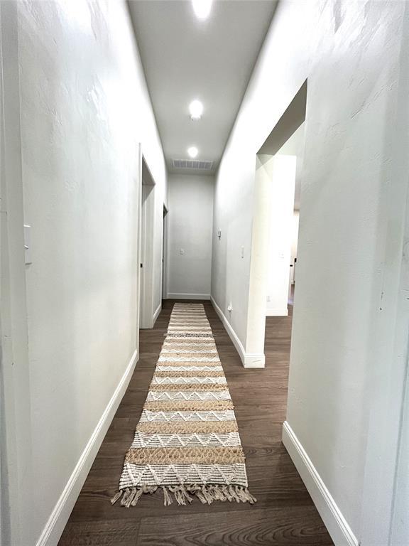213 W 5th St, Stroud, OK 74079 - hallway with dark wood-type flooring and baseboards