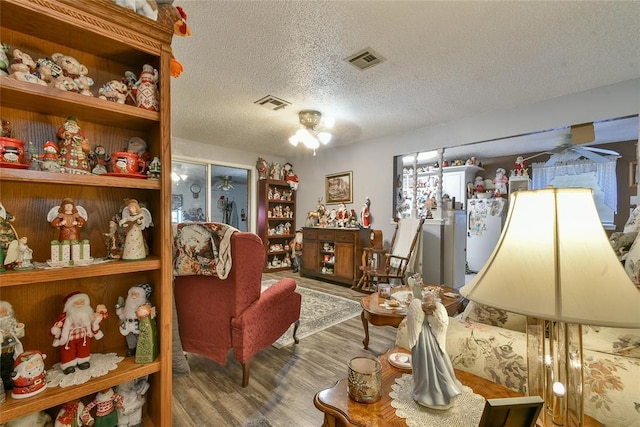 5505 S Dimple Dr, Oklahoma City, OK 73135 - living room featuring wood finished floors, a textured ceiling, and a ceiling fan