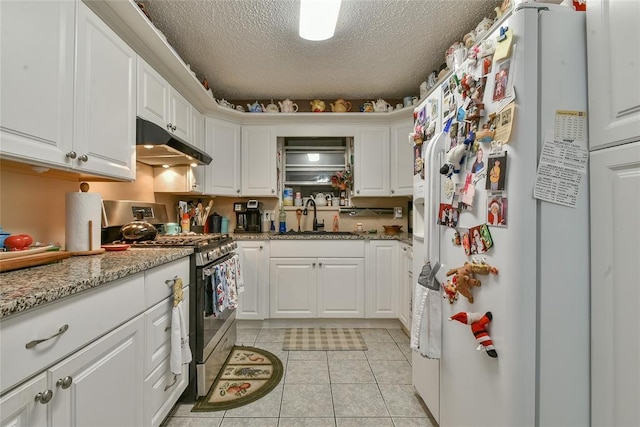 5505 S Dimple Dr, Oklahoma City, OK 73135 - kitchen with white refrigerator with ice dispenser, stainless steel gas range oven, under cabinet range hood, light tile patterned floors, and white cabinets