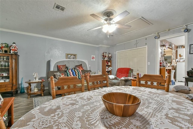 5505 S Dimple Dr, Oklahoma City, OK 73135 - bedroom featuring attic access, a textured ceiling, ornamental molding, wood finished floors, and ceiling fan