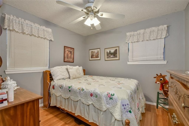 5505 S Dimple Dr, Oklahoma City, OK 73135 - bedroom featuring wood finished floors, a textured ceiling, and a ceiling fan