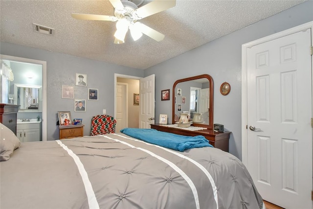 5505 S Dimple Dr, Oklahoma City, OK 73135 - bedroom featuring a textured ceiling, ceiling fan, and ensuite bath