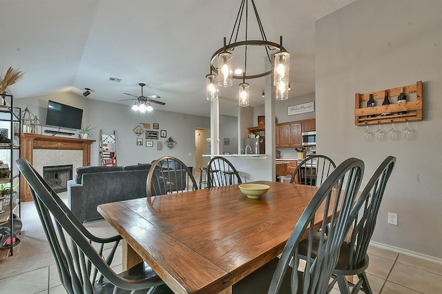 4616 Midway Dr, Norman, OK 73072 - dining room with light tile patterned flooring, ceiling fan, lofted ceiling, a fireplace, and a chandelier