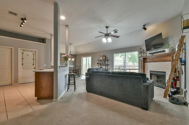 4616 Midway Dr, Norman, OK 73072 - living area with a ceiling fan, light carpet, a tile fireplace, vaulted ceiling, and rail lighting