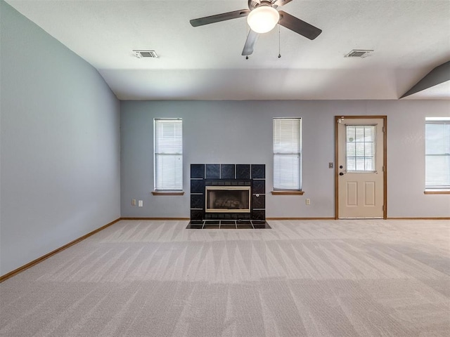 321 Bradgate Dr, Yukon, OK 73099 - unfurnished living room featuring carpet, healthy amount of natural light, a tiled fireplace, lofted ceiling, and ceiling fan