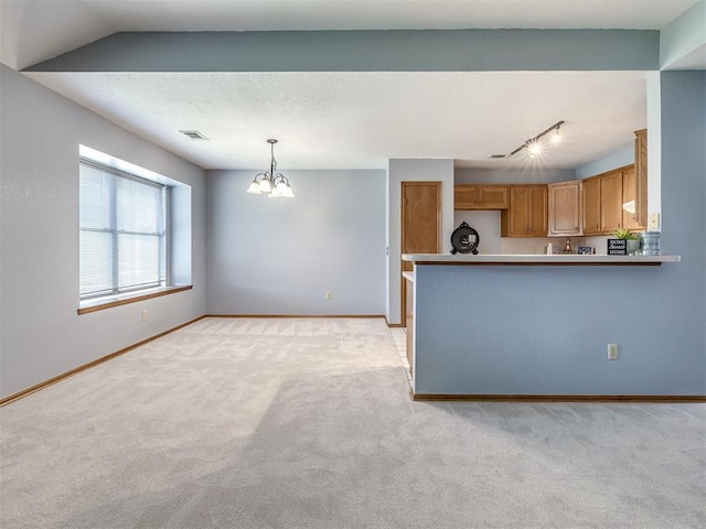 321 Bradgate Dr, Yukon, OK 73099 - kitchen featuring light carpet, a chandelier, a peninsula, and pendant lighting