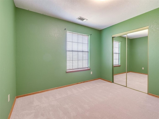 321 Bradgate Dr, Yukon, OK 73099 - unfurnished bedroom with carpet, a closet, and a textured ceiling