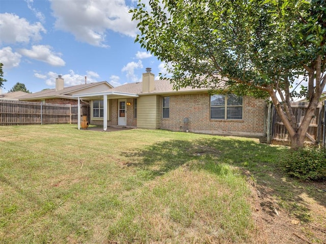 321 Bradgate Dr, Yukon, OK 73099 - back of house featuring brick siding, a fenced backyard, a patio area, and a chimney