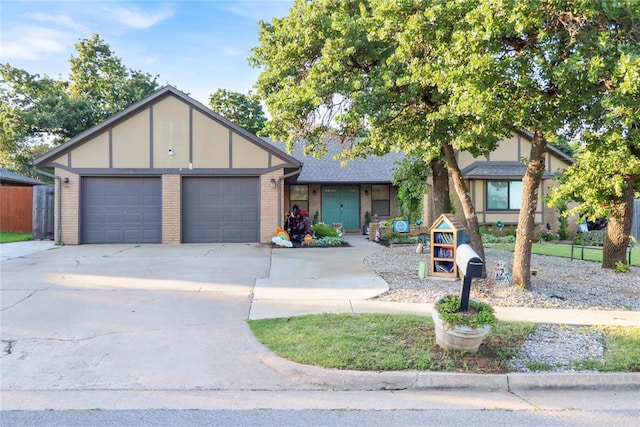 4213 NE 143rd St, Edmond, OK 73013 - view of front of home with a garage, concrete driveway, and brick siding