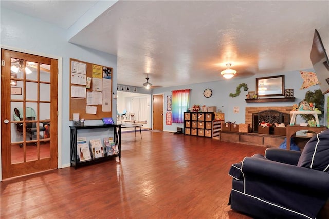 4213 NE 143rd St, Edmond, OK 73013 - living area with a stone fireplace, wood finished floors, and a ceiling fan