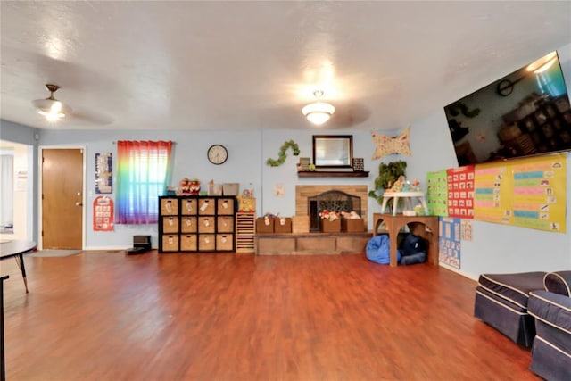 4213 NE 143rd St, Edmond, OK 73013 - living area featuring a stone fireplace, wood finished floors, and a ceiling fan