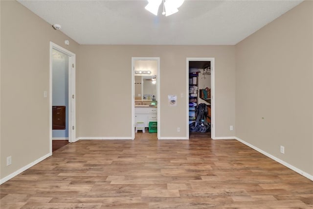4213 NE 143rd St, Edmond, OK 73013 - unfurnished bedroom with wood finished floors, ensuite bath, a spacious closet, and a closet