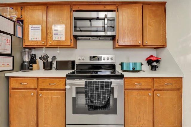 4213 NE 143rd St, Edmond, OK 73013 - kitchen featuring appliances with stainless steel finishes, light countertops, and brown cabinetry