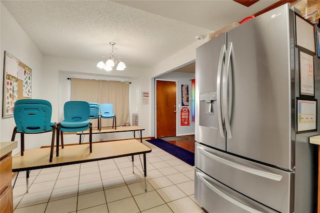 4213 NE 143rd St, Edmond, OK 73013 - kitchen featuring stainless steel refrigerator with ice dispenser, a chandelier, light tile patterned flooring, and a textured ceiling
