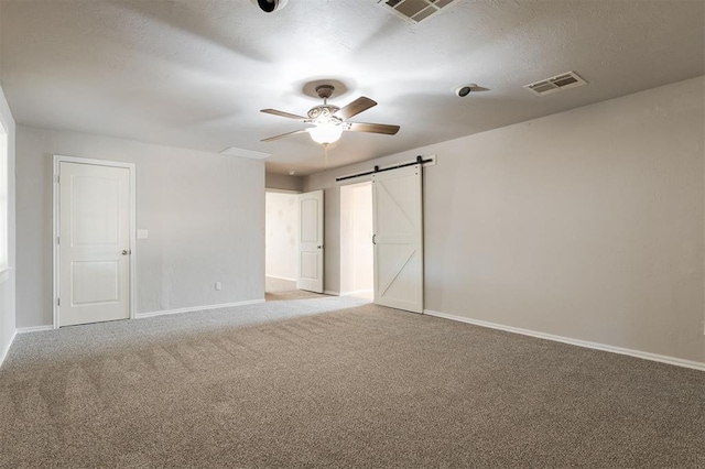 300 Yukon Ave, Yukon, OK 73099 - unfurnished bedroom with a barn door, carpet, and a ceiling fan