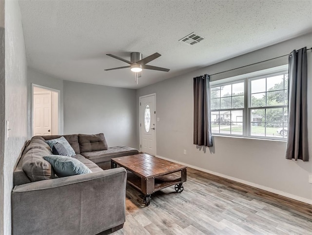 1508 Loftin Dr, Midwest City, OK 73130 - living room featuring light wood-style flooring, ceiling fan, and a textured ceiling