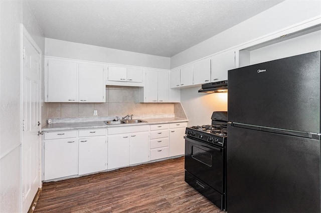 3701 Woodside Dr, Oklahoma City, OK 73110 - kitchen featuring black appliances, under cabinet range hood, light countertops, dark wood-type flooring, and a textured ceiling