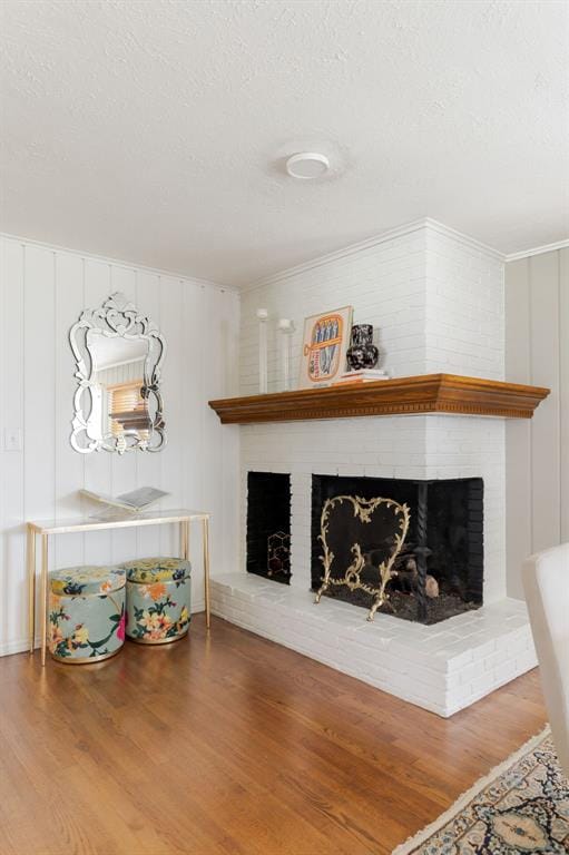 2800 Kerry Ln, Oklahoma City, OK 73120 - living area with a fireplace, wood finished floors, a textured ceiling, and crown molding