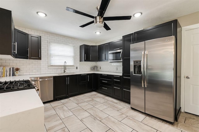 2800 Kerry Ln, Oklahoma City, OK 73120 - kitchen with stainless steel appliances, dark cabinetry, light countertops, a ceiling fan, and backsplash