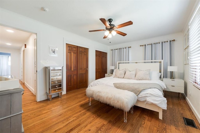 2800 Kerry Ln, Oklahoma City, OK 73120 - bedroom with two closets, light wood-style floors, multiple windows, and ceiling fan