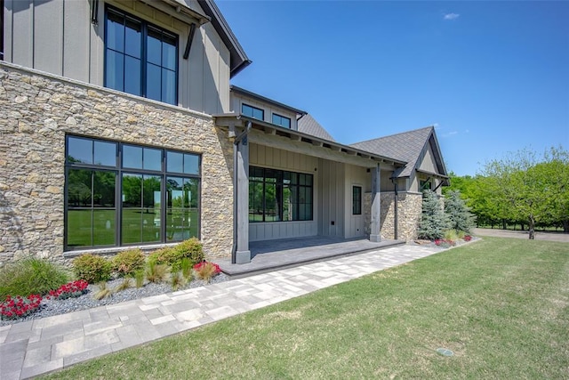 18569 310th St, Norman, OK 73072 - view of side of property featuring board and batten siding, stone siding, and a yard
